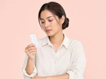 Naproxen vs ibuprofen — woman holding a painkiller blister pack